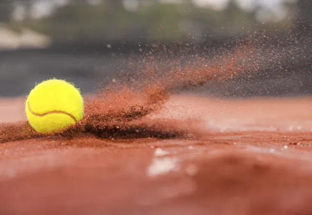 Tennisbollar som landar i grus som sprutar.